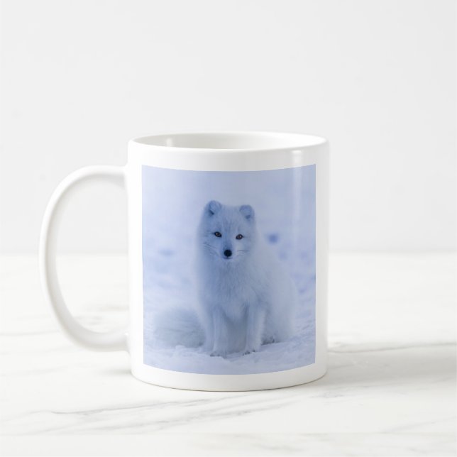 Niedlicher arktischer Fox im Hintergrund des schne Kaffeetasse (Links)