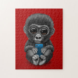 Niedlicher Baby-Gorilla, der ein Zellen-Telefon Puzzle