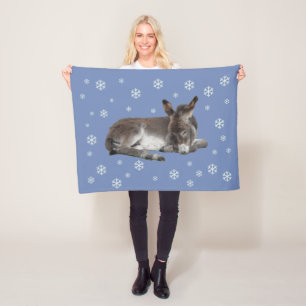 Niedlicher Babydonkey mit Schneeflocken auf blau Fleecedecke