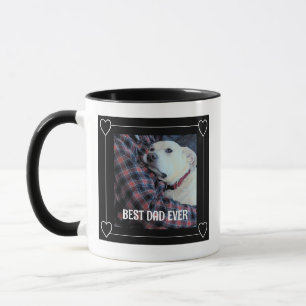 Niedlicher bester Vater je umarmender Welpenhund s Tasse