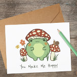 Niedlicher Frosch und Pilz | Du machst mich hoppen Karte<br><div class="desc">Diese niedliche Grußkarte ist mit einem handgezeichnet Cartoon-Frosch im kawaii-Stil ausgestattet,  der einen Pilzhut trägt,  zusammen mit anderen Pilzen,  einer Schnecke,  einer Blume,  einem Schmetterling und Gras. Text lautet "You Make Me Hoppy",  kann aber auf Wunsch angepasst werden.</div>