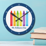 Niedlicher Kindergarten Lehrer Custom Crayon Unter Runde Wanduhr<br><div class="desc">Eine wunderschöne Lehrer-Wertungswoche oder Jahresende-Geschenk für einen Kindergarten-Klasse,  um ihren Grundschullehrer zu geben. Maßgeschneiderte Uhr mit ihrem Namen in blau angepasst. Personalisieren Sie mit Ihrem Namen oder Text unter dem niedlichen Regenbogen der Stifte. Ein bezauberndes Geschenk für einen Vorschullehrer.</div>