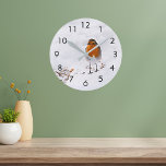 Niedlicher Robin-Vogel Runde Wanduhr<br><div class="desc">Fütternd Vögel während der kalten Wintersaison. Ein niedlicher Robin,  der in einen Garten kommt,  Hinterhof für die Sonnenblumenkerne,  die im Schnee liegen. Schwarze Zahlen.</div>