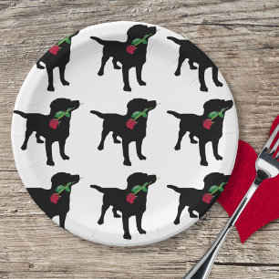 Niedlicher schwarzer Labrador-Hund, der Rote Rose Pappteller