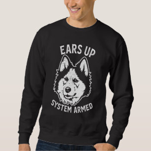 Niedlicher sibirischer Husky-Hund hört Welpen auf Sweatshirt