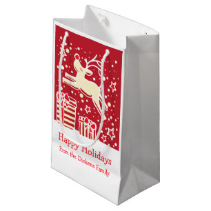 Niedliches Ren, das über Weihnachtsgeschenktasche Kleine Geschenktüte