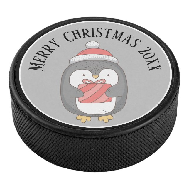 Niedliches Weihnachtspenquin mit Hut und Packung Eishockey Puck (3/4)