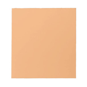 Notizblock mit pastellorangefarbenem Hintergrund