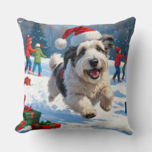 Old English Sheepdog läuft im Schnee mit Weihnacht Kissen