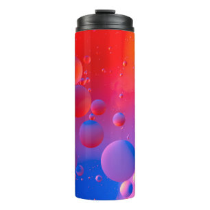 ölige Tropfen in Wasser mit farbigem Hintergrund, Thermosbecher