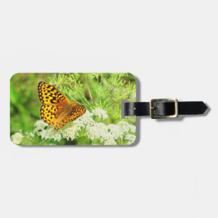 Orange und schwarzer Schmetterling mit weißen Gepäckanhänger