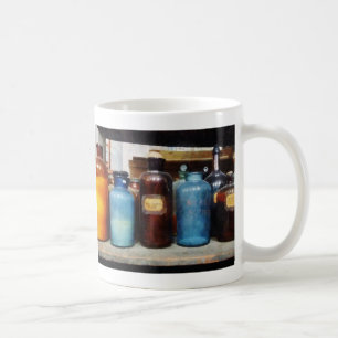 Orangefarbene, braune und blaue Chemikalienflasche Kaffeetasse