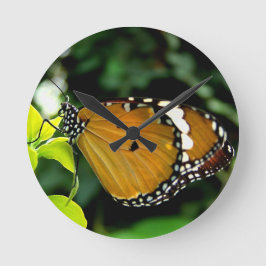 Orangefarbene, schwarze und weiße Schmetterlinge a Runde Wanduhr