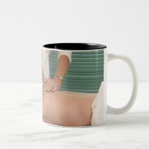 Osteopath/Chiropraktor, der zurück manipuliert Zweifarbige Tasse