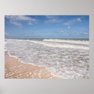 Ozean-Wellen, die den Sand auf dem Strand bedecken Poster