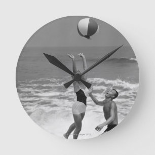 Paar spielt mit einem Strandball Runde Wanduhr