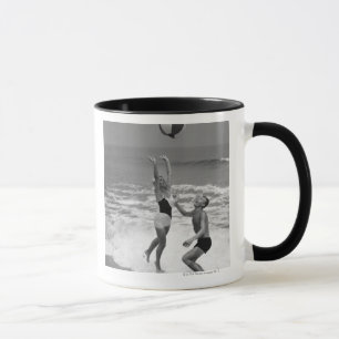 Paare, die mit einem Beachball spielen Tasse