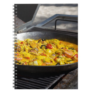 Paella wird auf einem Grill zubereitet Notizblock