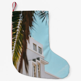 Palmenbaum in der Nähe von weißem Beton Gebäude Kleiner Weihnachtsstrumpf