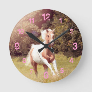 Palomino Paint Pferd galoppiert über eine Wiese Runde Wanduhr