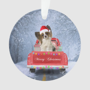 Papillon Hund im Schnee sitzen im Weihnachtswagen Ornament