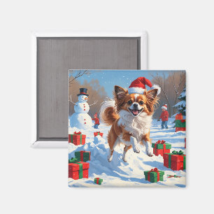 Papillon-Hund läuft im Schnee mit Weihnachtsmütze Magnet