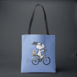 Peanuts | Snoopy & Woodstock Bicycle<br><div class="desc">Pedal into style and classic charm with this adorable cream canvas tote bag, featuring Snoopy and Woodstock on a bicycle! This fun tote showcases a delightful line-art illustration of Snoopy, wearing sunglasses, happily riding a vintage-style blue bicycle with Woodstock perched safely behind him. The dashed lines behind the back wheel...</div>