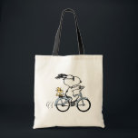 Peanuts | Snoopy & Woodstock Bicycle Tragetasche<br><div class="desc">Pedal into style and classic charm with this adorable cream canvas tote bag, featuring Snoopy and Woodstock on a bicycle! This fun tote showcases a delightful line-art illustration of Snoopy, wearing sunglasses, happily riding a vintage-style blue bicycle with Woodstock perched safely behind him. The dashed lines behind the back wheel...</div>