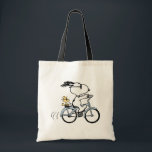 Peanuts | Snoopy & Woodstock Bicycle Tragetasche<br><div class="desc">Pedal into style and classic charm with this adorable cream canvas tote bag, featuring Snoopy and Woodstock on a bicycle! This fun tote showcases a delightful line-art illustration of Snoopy, wearing sunglasses, happily riding a vintage-style blue bicycle with Woodstock perched safely behind him. The dashed lines behind the back wheel...</div>