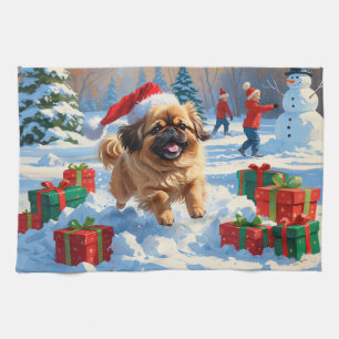 Pekingeser Hund läuft im Schnee mit Weihnachtsmütz Geschirrtuch
