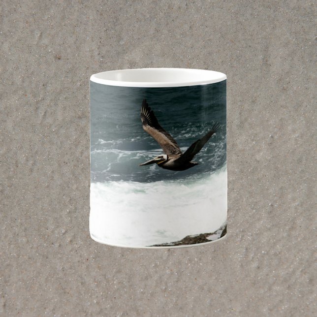 Pelican Flying Over Rocks and Ocean Fotografy Kaffeetasse (A mug with a photograph of a flying pelican over the Pacific ocean)