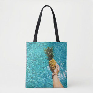 Person holding yellow pineapple