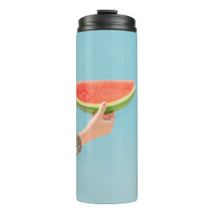 Person mit Wassermelone in Scheiben Thermosbecher
