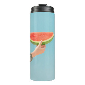 Person mit Wassermelone in Scheiben Thermosbecher