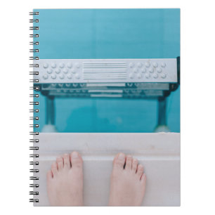 Person standing on swimming pool ladder notizblock