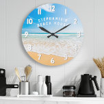 Personalisiert Beach House Tropical Beach Szene Große Wanduhr<br><div class="desc">Personalisiertes Beach House Tropical Beach Scene große Uhr. Diese Wasseruhr eignet sich perfekt für eine Zuhause an der Küste. Dieses Stranddesign besticht durch den Sand der Meere. Personalisieren Sie mit Ihrem eigenen Namen oder Text.</div>