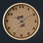 Personalisierte Herz Carved Initials Wood Tree Rin Uhr<br><div class="desc">Diese wunderschöne Uhr eignet sich perfekt für eine Hochzeit, ein Jubiläum oder einen Valentinstag. Das grafische Design hat eine Holzstruktur, wie die obere Ansicht eines Baumstumpfes mit Ringen und einer Rinde Rand. Es wurde ein Herz mit Pfeil eingemeißelt, zusammen mit holzaussehenden braunen Zahlen. Verwenden Sie das Vorlagenfeld, um einfach zwei...</div>