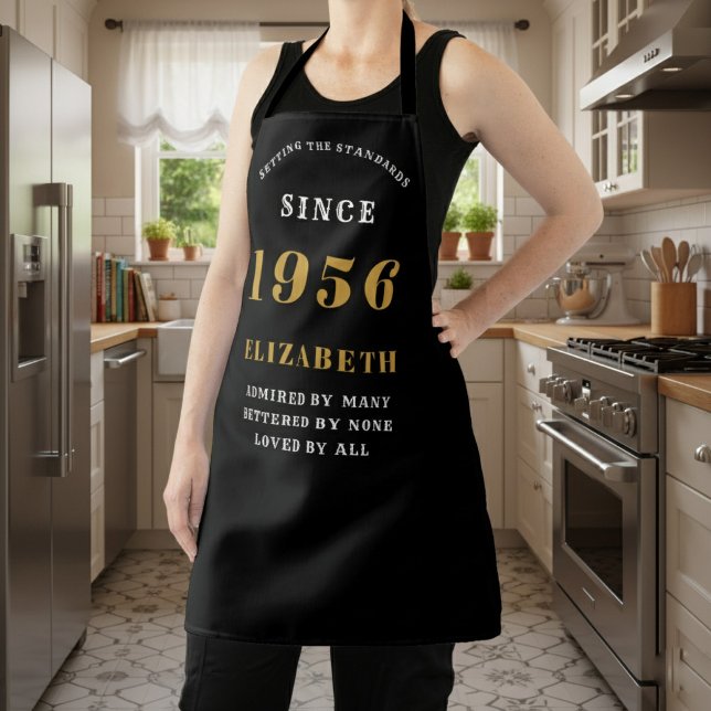 Personalisierter 70. Geburtstag 1956 Schwarz & Gol Schürze (birthday 1956 apron worn in a kitchen.)