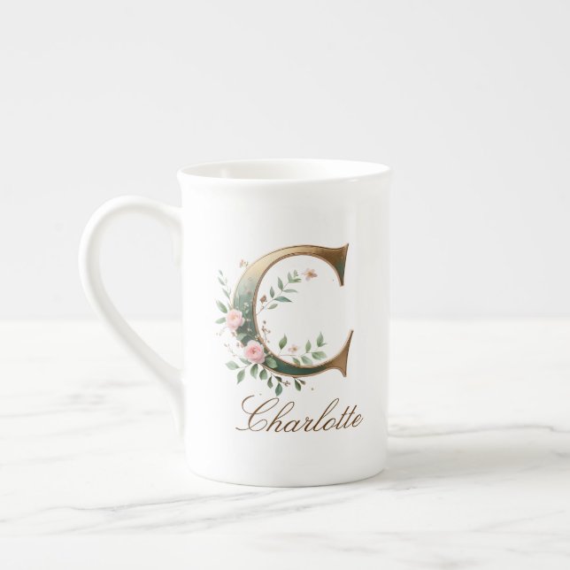 Personalisierter goldener Blumenmonogramm-Initiale Prozellantasse (Links)