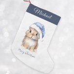 Personalisierter Hase in Blue Santa Kleiner Weihnachtsstrumpf<br><div class="desc">Personalisierter Weihnachts-Weihnachten-Strumpf, perfekt für Ihre Kleinen in dieser Ferienzeit. Dieser bezaubernde Strumpf ist mit einem niedlichen kleinen Hasen versehen, der einen schneebedeckten blauen Hut des Weihnachtsmanns trägt. Strumpf kann mit dem Namen Ihres Kindes personalisiert sein. Halten Sie es auf Ihrem Kaminzimmer oder im Kinderzimmer, um Ihrer Zuhause eine festliche Touch...</div>
