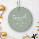 Personalisierter Verlobter Couple Handgeschriebene Keramik Ornament<br><div class="desc">Feiern Sie Ihr erstes Weihnachtsfest als verlobtes Paar mit diesem personalisierten Keramik-Ornament, mit einem skurrilen, handgeschriebenen Drehbuch in Weiß auf einem schluchgrünen Hintergrund. Das elegante und dennoch spielerische Design verleiht Ihrer Feriendekoration eine Touch von Charme und Eleganz und macht sie zu einem perfekten Sake für diesen besonderen Meilenstein. Personalisieren Sie...</div>