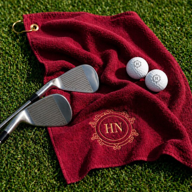 Personalisiertes Burgunder Golfhandtuch mit Initia (Rich burgundy luxury golf towel and monogrammed golf balls flat lay.)
