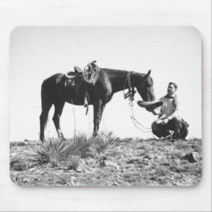 Pferd frisst aus dem Hut eines Cowboys. Mousepad