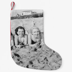 Portrait von fünf jungen Frauen, die am Strand lie Kleiner Weihnachtsstrumpf
