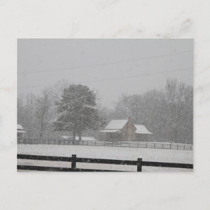 Postkartenschnee fällt auf einen Bauernhof. Feiertagspostkarte