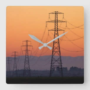 Power Pylons bei Sonnenuntergang Quadratische Wanduhr