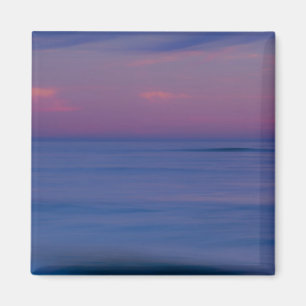 Purple-colored sunrise on ocean shore magnet