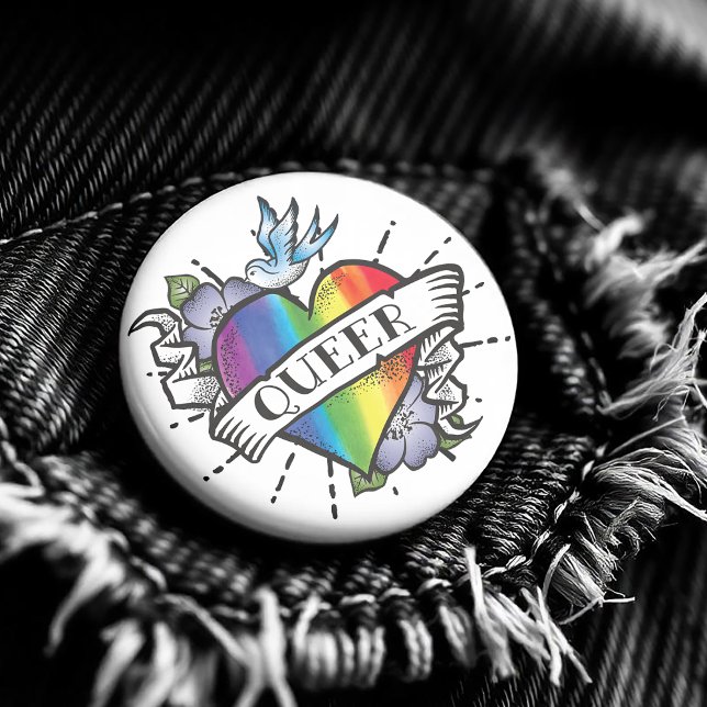Que Heart Tattoo Button ( Featuring a realistic image of a rainbow colored heart with Queer proudly written on the front. )