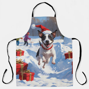 Ratt Terrier läuft im Schnee mit Weihnachtsmütze Schürze