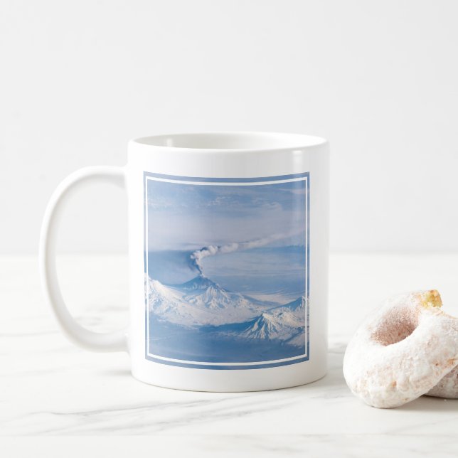 Rauch aus dem Vulkan Kliuchevskoi. Kaffeetasse (Mit Donut)